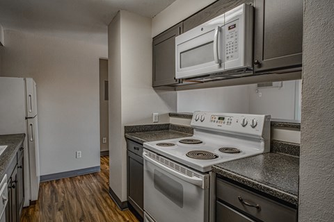 an empty kitchen with white appliances and a white microwave